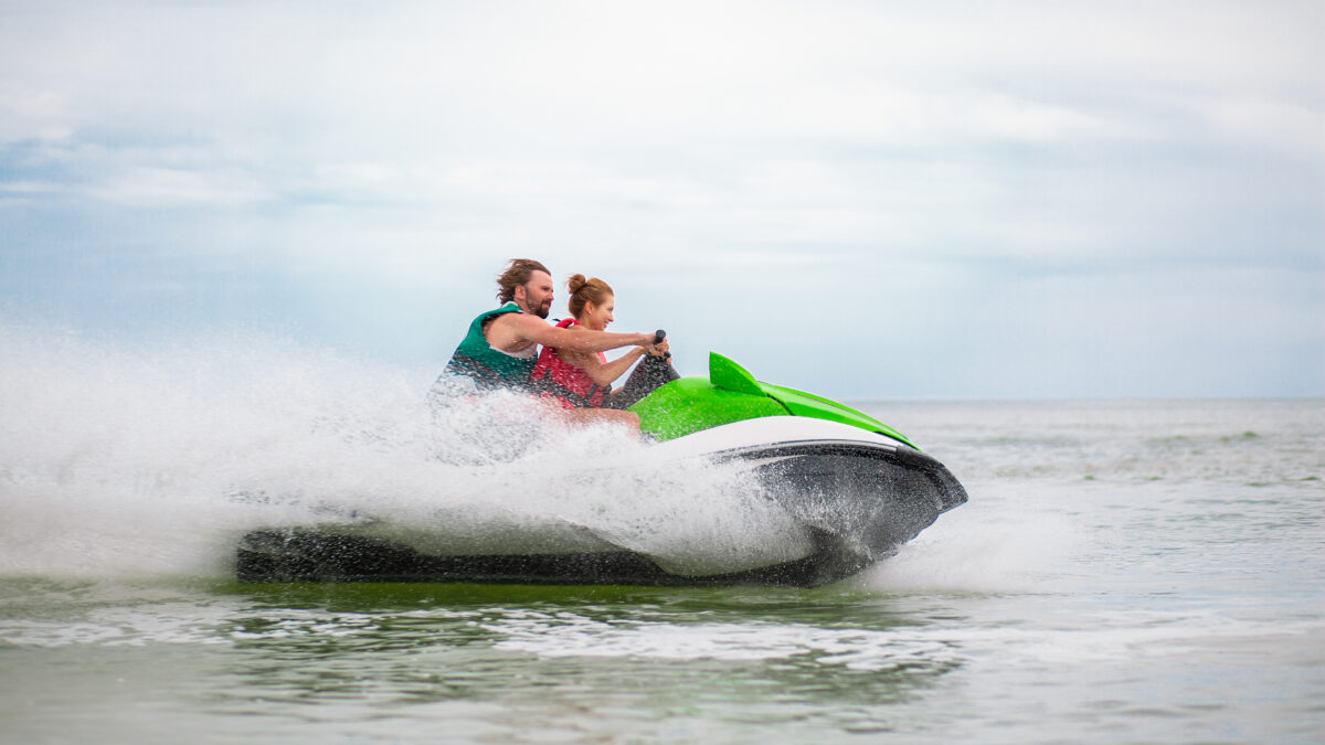 couple having fun on water scooter summer sea activity young people having fun driving on high speed on water scooter, man and woman on summer vacation, friends doing active sport